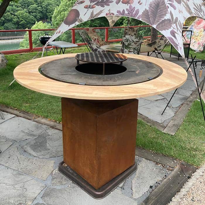 Corten steel grill with wooden table sides